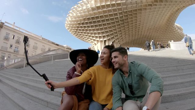 Low angle, friends take photo under Metropol Parasol