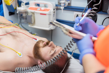 Emergency doctor filling patient history list at clipboard pad in the ambulance © herraez