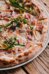 Pizza carbonara on rustic wooden table