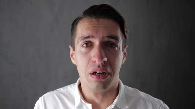 Portrait of sad man crying with tears in eyes. Depressed businessman crying. Man in despair.