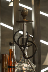 Beautiful glass hookah on a wooden table in a hookah bar.