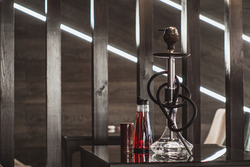 Beautiful glass hookah on a wooden table in a hookah bar.