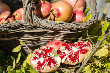 Pomegranates in the basket, seasonal fruit, important food supplement rich in vitamins and antioxidants; excellent ingredient for cheerful and colorful menus and cocktails.