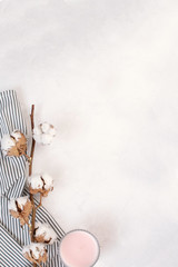 Minimal autumn decor concept - Dried cotton branch, candle on Crumpled Striped Napkin, white background.