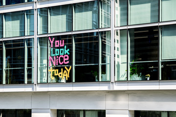 You look nice today written by employees with colorful stick notes on a company window.