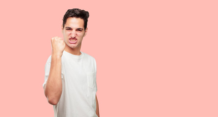 young handsome man gesturing victory, with a happy, proud and satisfied look on face and holding...