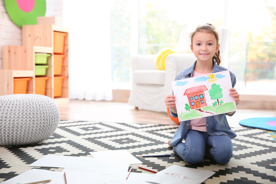 Little girl with painting sitting on floor at home