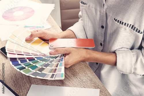 Woman with color palette samples at table, closeup