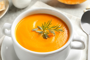 Delicious pumpkin cream soup in bowl on table, closeup