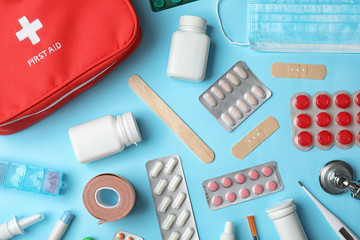 Flat lay composition with first aid kit on color background