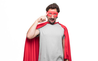 Young bearded super hero looking happy and surprised, smiling and thinking of an amazing new idea or solution, excited with epiphany and sudden inspiration. © kues1
