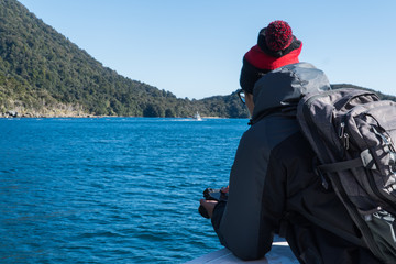 Man looking over the side of a boat with his camera