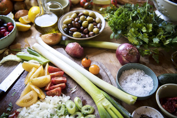 A busy kitchen top with vegetable and ingredients