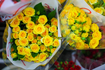 bouquets roses for sale at florist's shop on street flower market with transparent wrapping paper