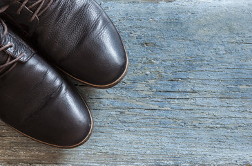Classic male brown leather shoes on wooden background