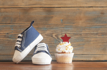 Delicious birthday сupcakes for a baby shower on wooden background