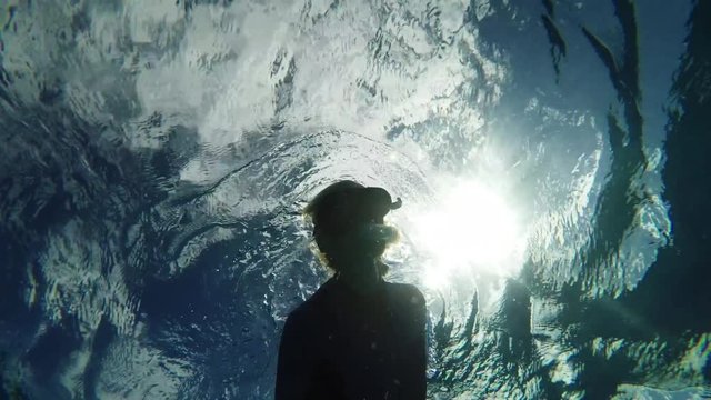 Low angle, scuba diver swims in slow motion