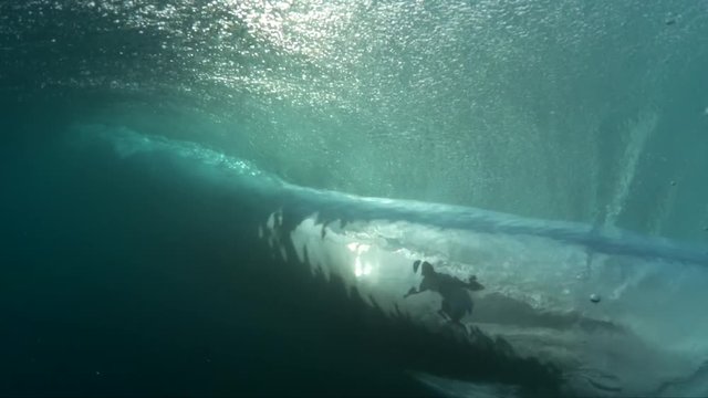 View of surfer catching wave from underwater, slow motion