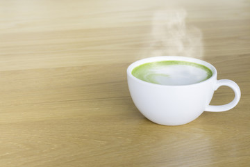 Hot Green tea mail cup,Matcha latte and beans on wooden table, in the morning