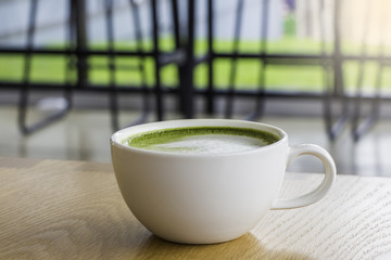 Hot Green tea mail cup,Matcha latte and beans on wooden table, in the morning
