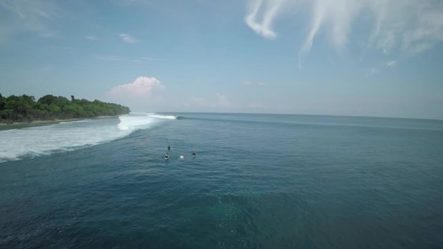 Wide aerial, surfers off coast of Mentawai Island