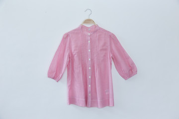 Pink women shirt is clothes hanger on white background.