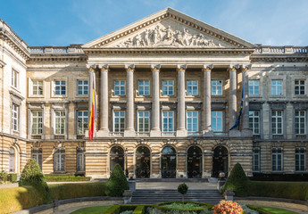 Fototapeta premium Brussels, Belgium - September 26, 2018: Closeup of front Facade of Belgian Parliament in romanesque style with pillars and fresco triangle, and Belgian and European flag.