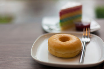 Plain donuts with rainbow cake background