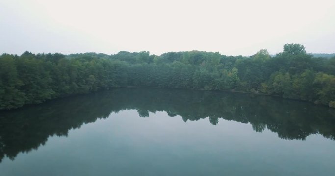 Aerial of a beautiful foggy lake in the morning in de middle of a forest.