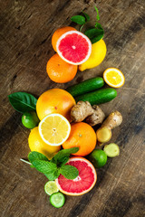 Raw fruit whole and cut on wooden background, as a lemon, grapefruit, orange, mint, cucumber and ginger