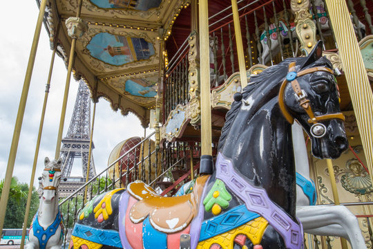 View of the eiffel tower through a merry-go-round on a cloudy day