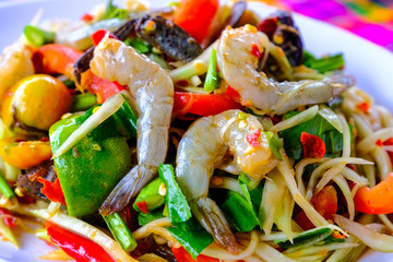 Som Tam Seafood (Spicy Papaya Salad) with salted crab, on wooden table ( Thai food)