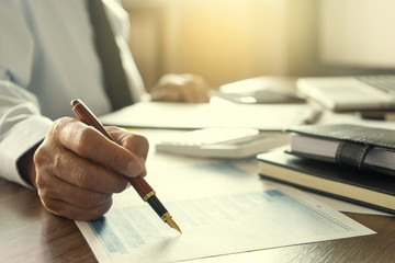 Businessman work with computer on table in office work with paper graph chart