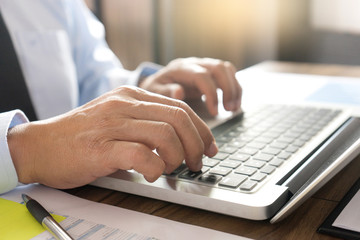 Businessman work with computer on table in office work with paper graph chart