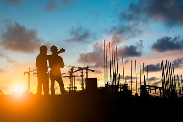 Silhouette of engineer and construction team working at site over blurred background for industry...