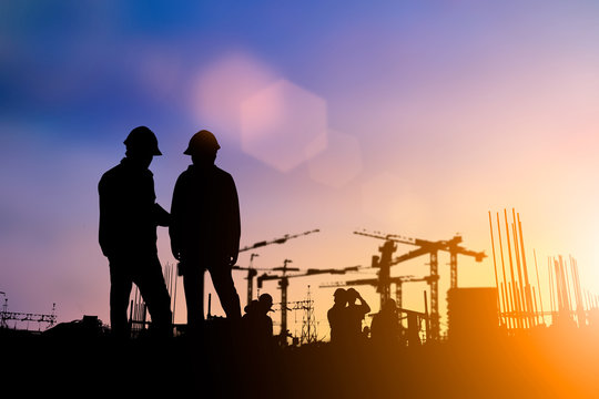 Silhouette of engineer and construction team working at site over blurred background for industry background with Light fair.Create from multiple reference images together