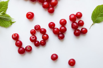 Red cherries on white are lined with the word love. Summer fruits and berries concept. Top view, flat lay