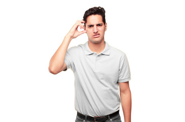 Young handsome tanned man with a goofy, dumb, silly look, feeling shocked and confused at a recent...