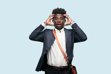 young black businessman with a crazy, amazed look of surprise, holding head with both hands,...