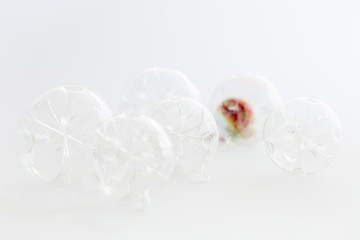 Still life with beautiful decorative transparent and red christmas glass balls on white background