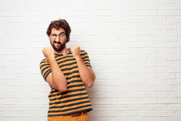 young dumb man with an angry, aggressive and menacing pose, ready for the fight, showing fists...