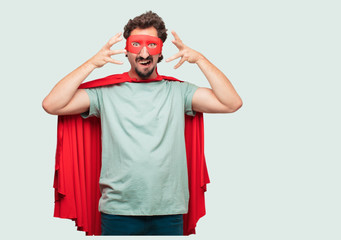 crazy man as a super hero shouting with a crazy, amazed look of surprise, holding head with both hands. © kues1