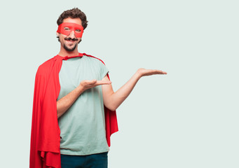 crazy man as a super hero smiling with a satisfied expression showing an object or concept with...