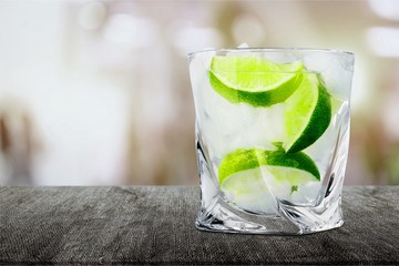 Glass of delicious cocktail with lime on