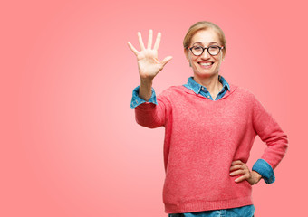 Beautiful senior woman smiling and looking satisfied and happy, counting number five with fingers, with an open palm.