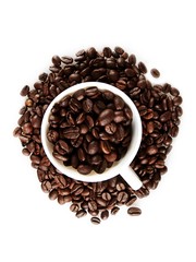 Mug full of, and surrounded by, coffee beans