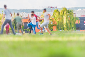 Obraz na płótnie Canvas Blurred young children football players running in park