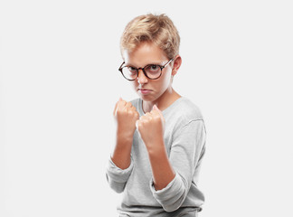 young blonde handsome boy with an angry, aggressive and menacing pose, ready for the fight, showing...