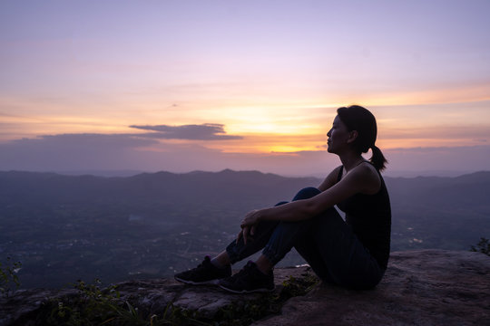 silhouette woman sitting on mountain © pigprox
