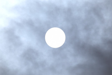 solar disk at noon through the clouds